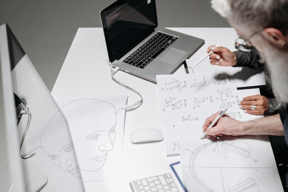 Team working on detailed technical drawings at a modern office desk.